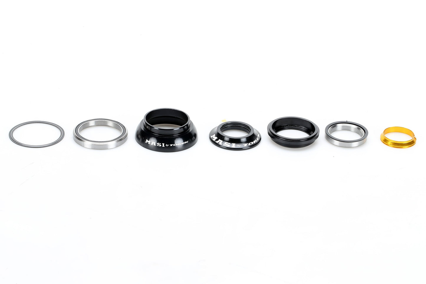 A linear display of the MASI TOKEN TAPPERED HEADSET from Masi Bikes, showcasing various metallic and plastic components on a white background. The parts vary in size and color, including silver, black, and gold.