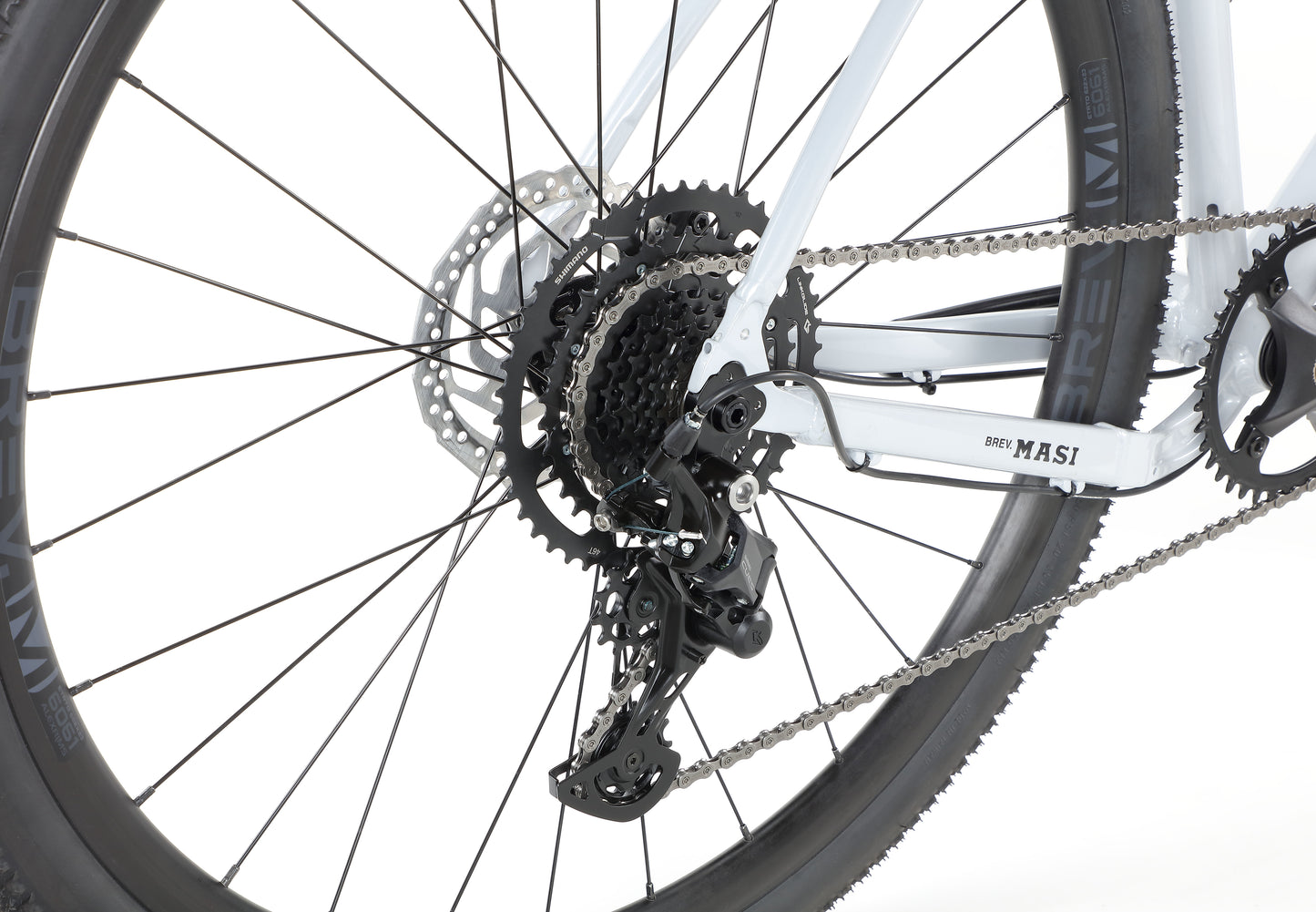Close-up of BRUNELLO 3s rear wheel and gear system, featuring the chain, sprockets, and derailleur on a white background.