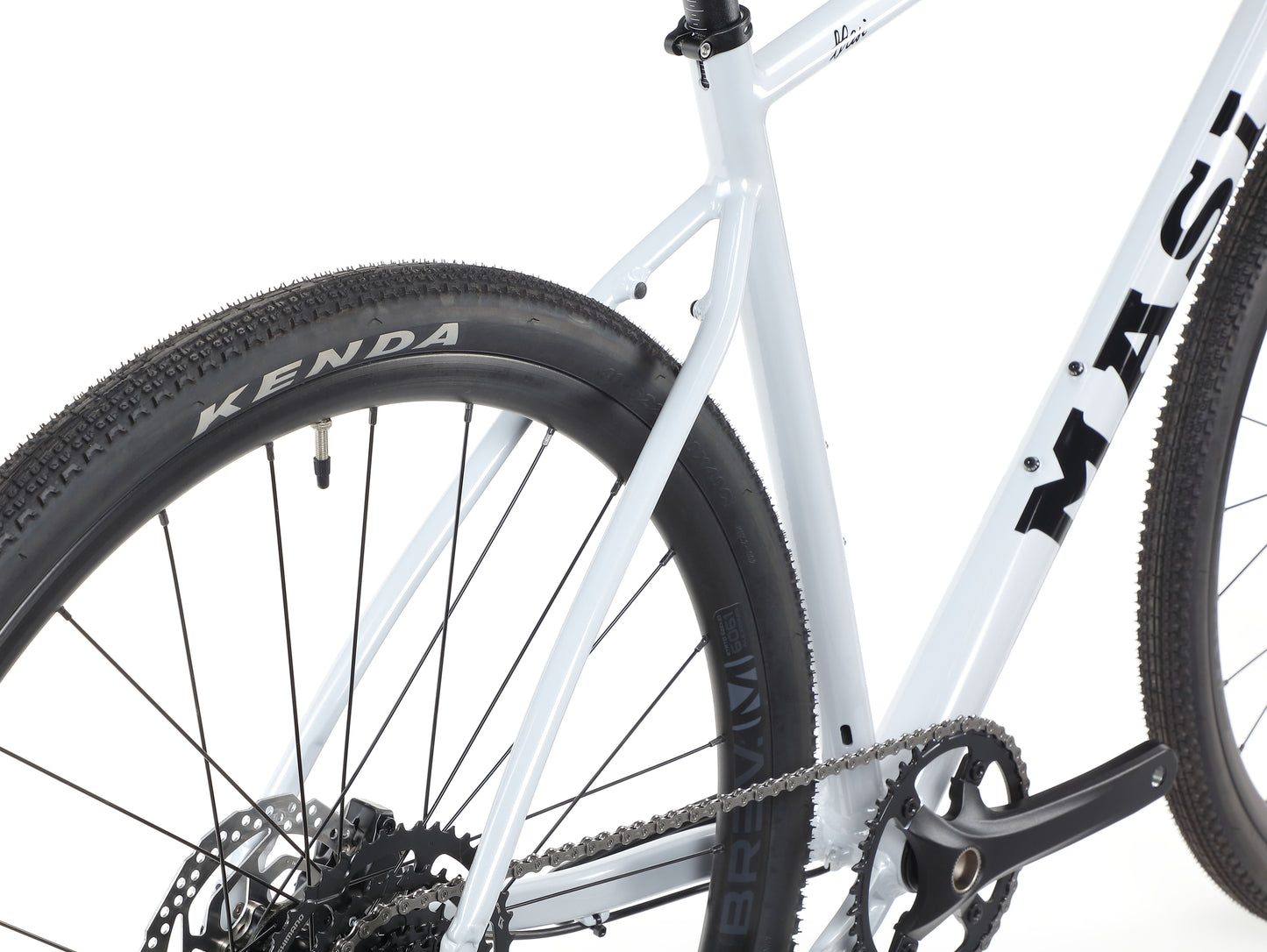 Close-up of the BRUNELLO 3s white frame, featuring the rear wheel with a Kenda tire and visible chainring and crankset.
