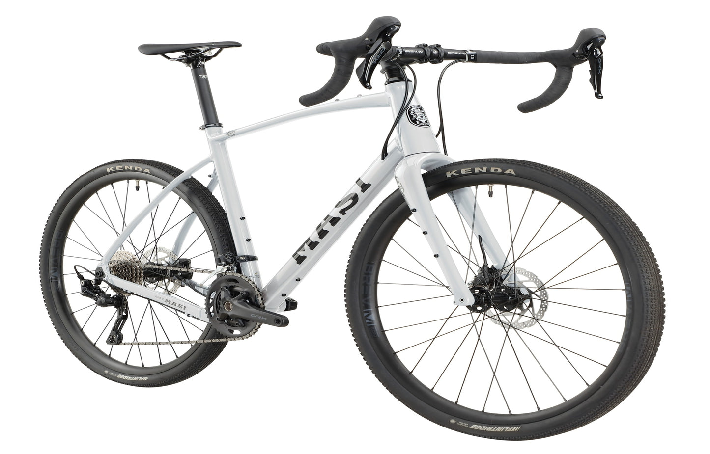 BRUNELLO 1: White gravel bike with black handlebars and tires, a sleek frame, disc brakes, and the brand logo on the down tube.