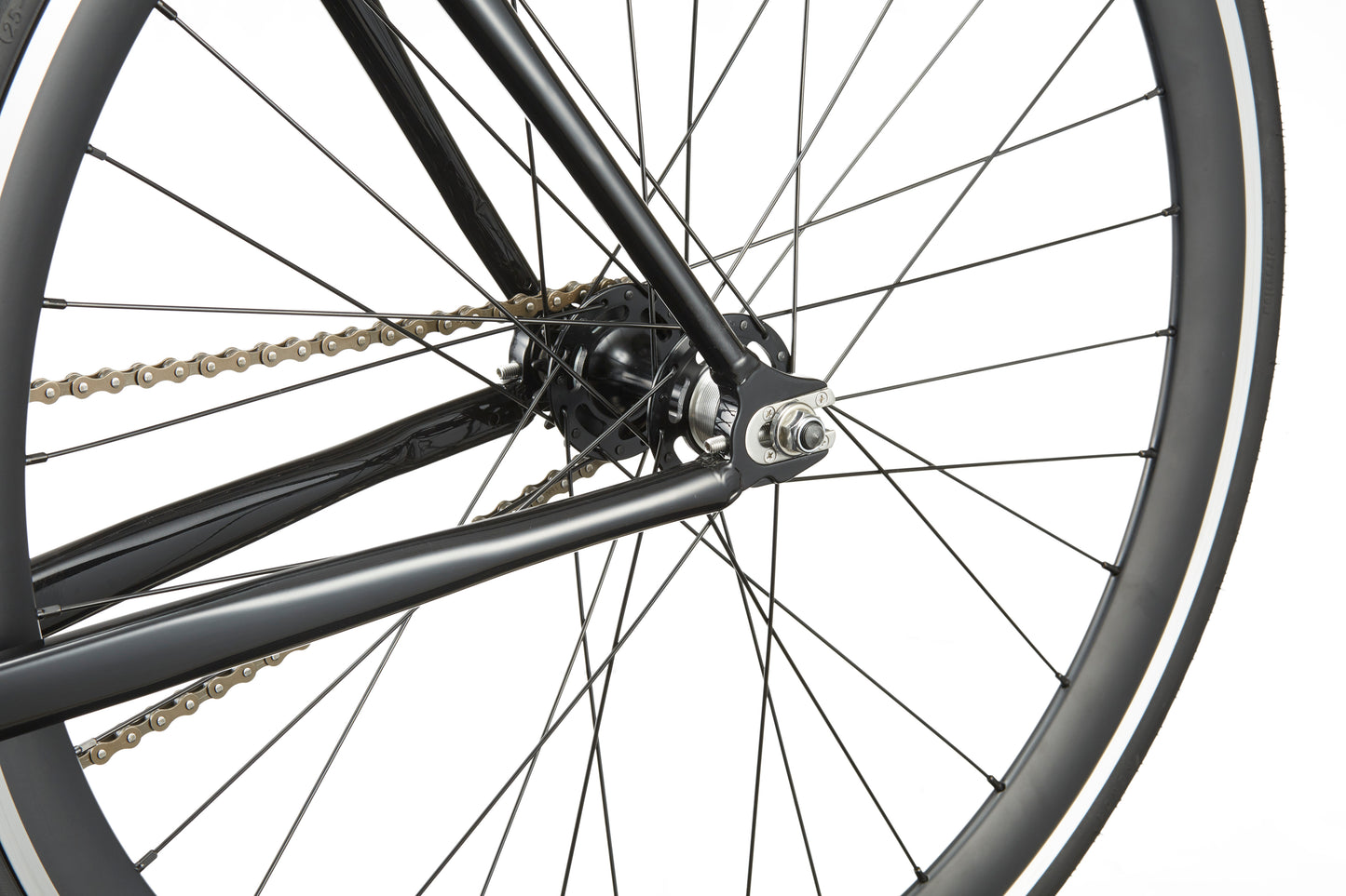 Close-up of the Coltello Geometry rear wheel, highlighting the chain, spokes, and black single-speed fixie frame.