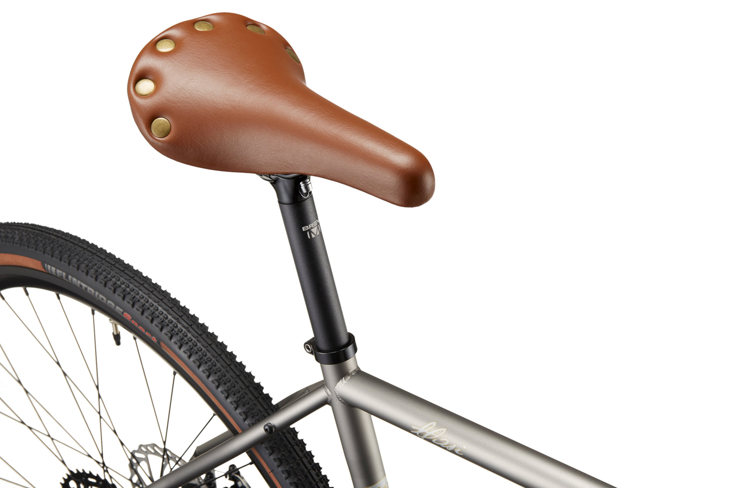 Close-up of the CATALINA 1 bike showing its brown leather saddle, black seat post, rear wheel, and chromoly steel frame.