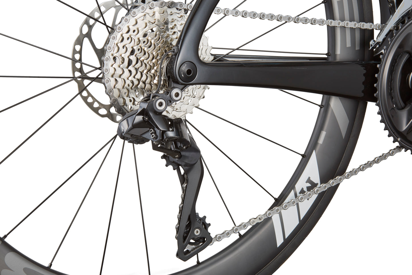 Close-up of EVOLUZIONE 1s rear derailleur and cassette, highlighting gears and chain on a black wheel with an aerodynamic design.
