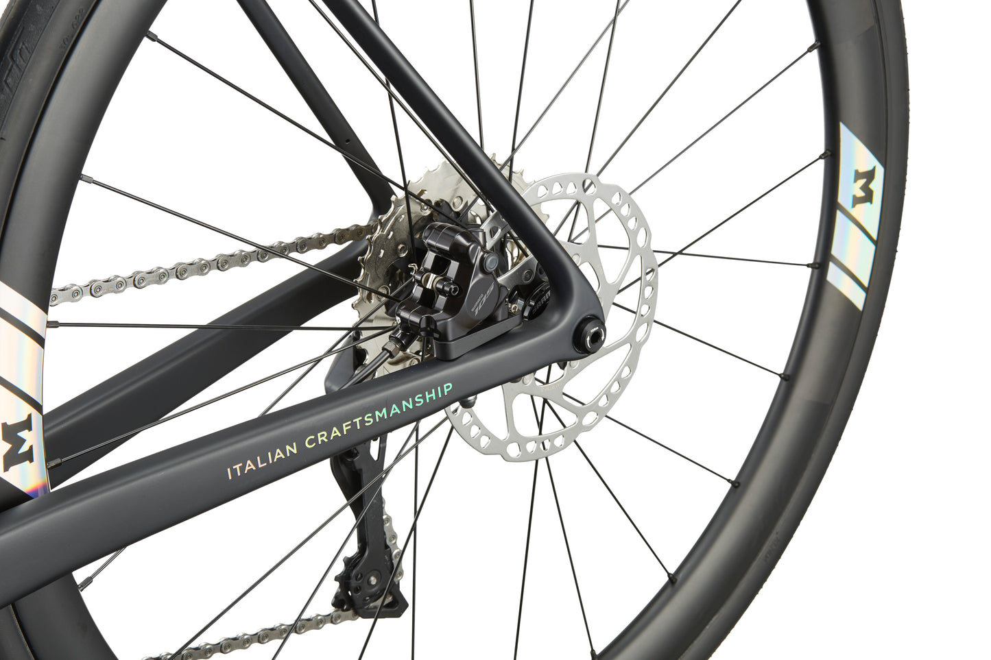 Close-up of the GRAN CORSA carbon road bike’s rear wheel, disc brake, chain, and Italian craftsmanship on the frame.