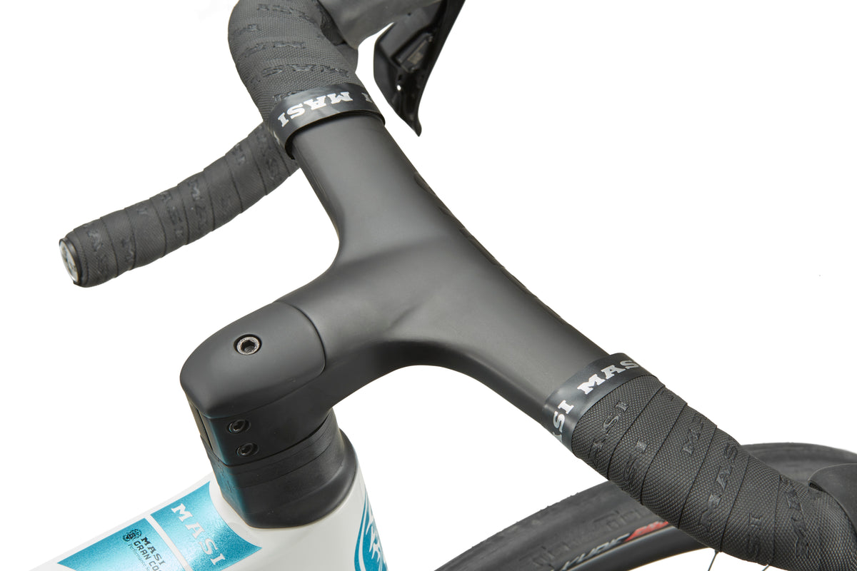 Close-up of black handlebars and stem with wrapped grips on a white GRAN CORSA carbon road bike frame and front wheel.