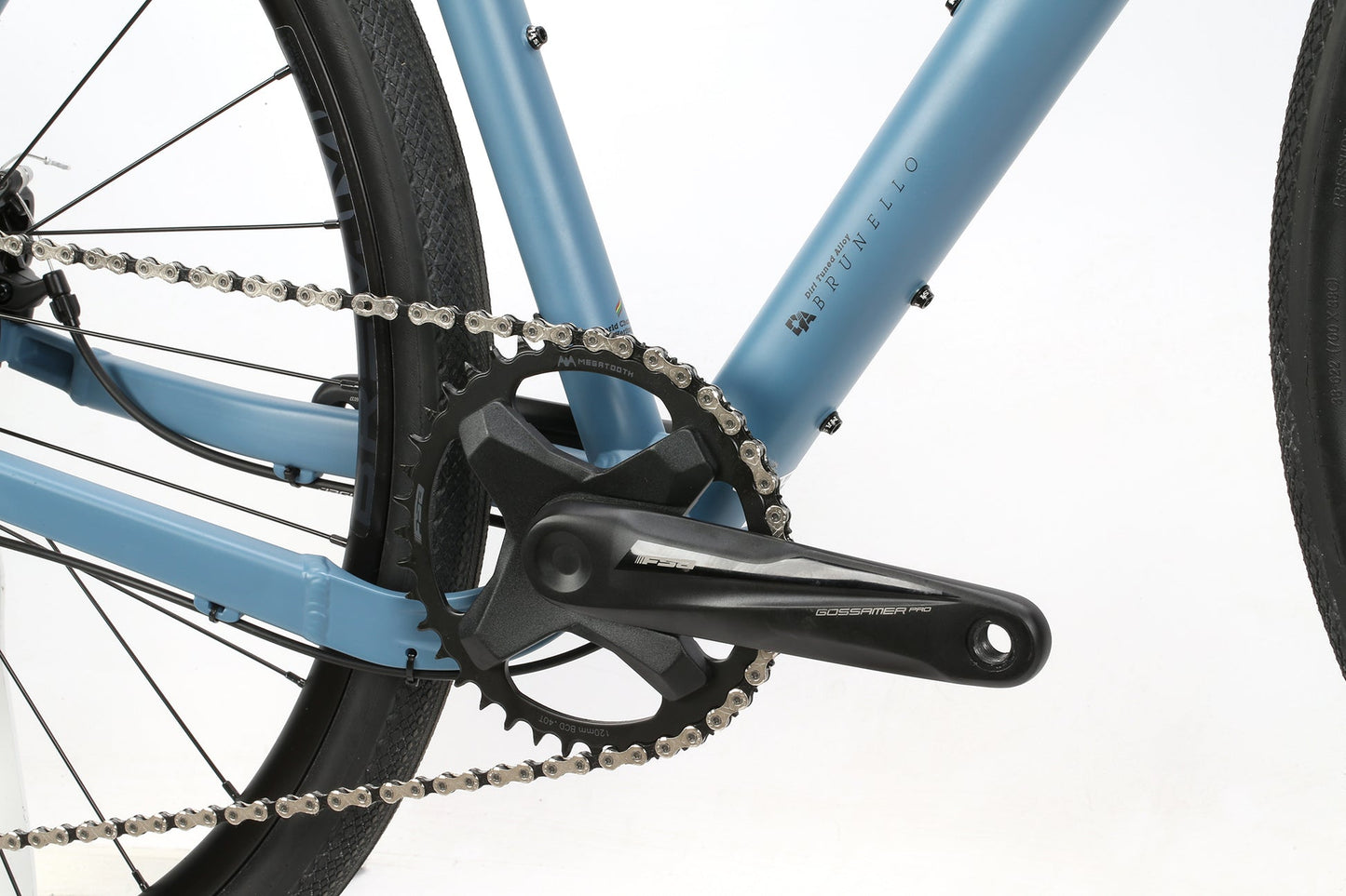 Close-up of the BRUNELLO ADXs 1X wide range clutch drivetrain on a blue aluminum gravel frame with black crankset and silver chain.