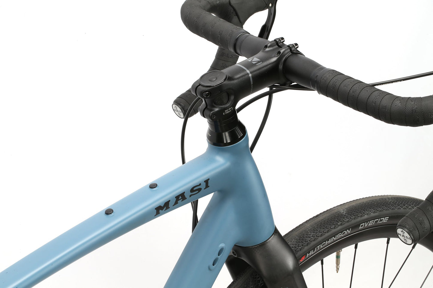 Close-up of a BRUNELLO ADX featuring a blue aluminum gravel frame, black grip tape, Hutchinson tires, and a full carbon fork.