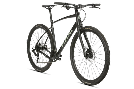 The BRUNELLO FB NOVE is a sleek black hybrid bicycle with knobby tires, an aluminum gravel frame, and flat handlebars, seen from the front.
