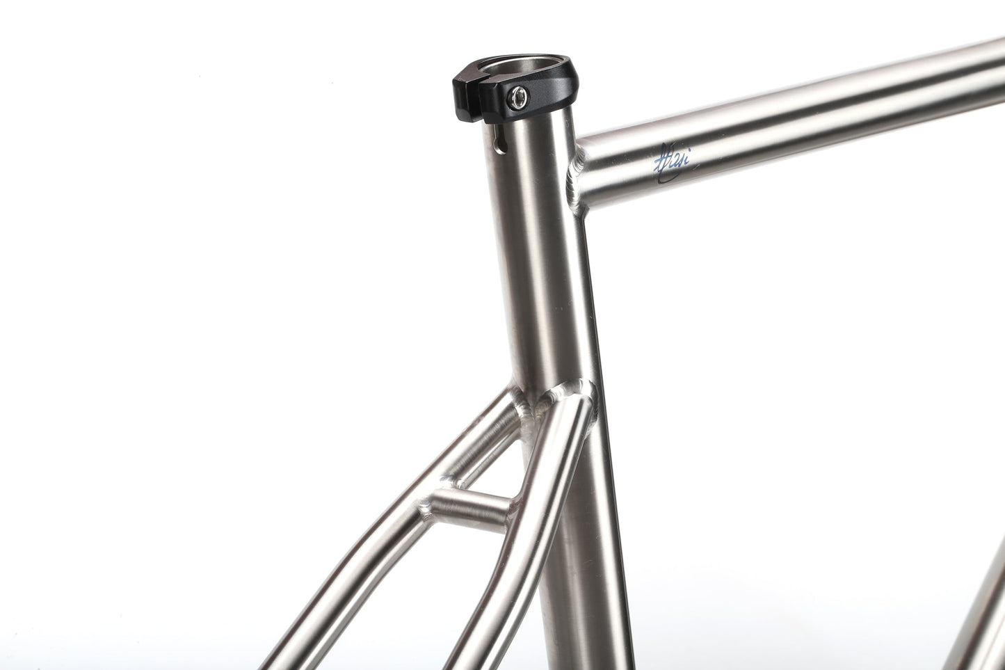 Close-up of the TITANIO FRAMESET by Masi Bikes shows the titanium race bikes seat post area, featuring clean welds, a sleek metallic finish, and 32c tire clearance that enhances its minimalist modern design against a white background.