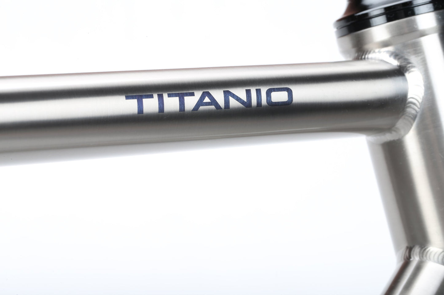 The Masi Bikes TITANIO FRAMESET showcases a polished titanium finish with TITANIO branding. Its sleek design on a plain white background highlights 32c tire clearance, ideal for versatile cycling adventures.
