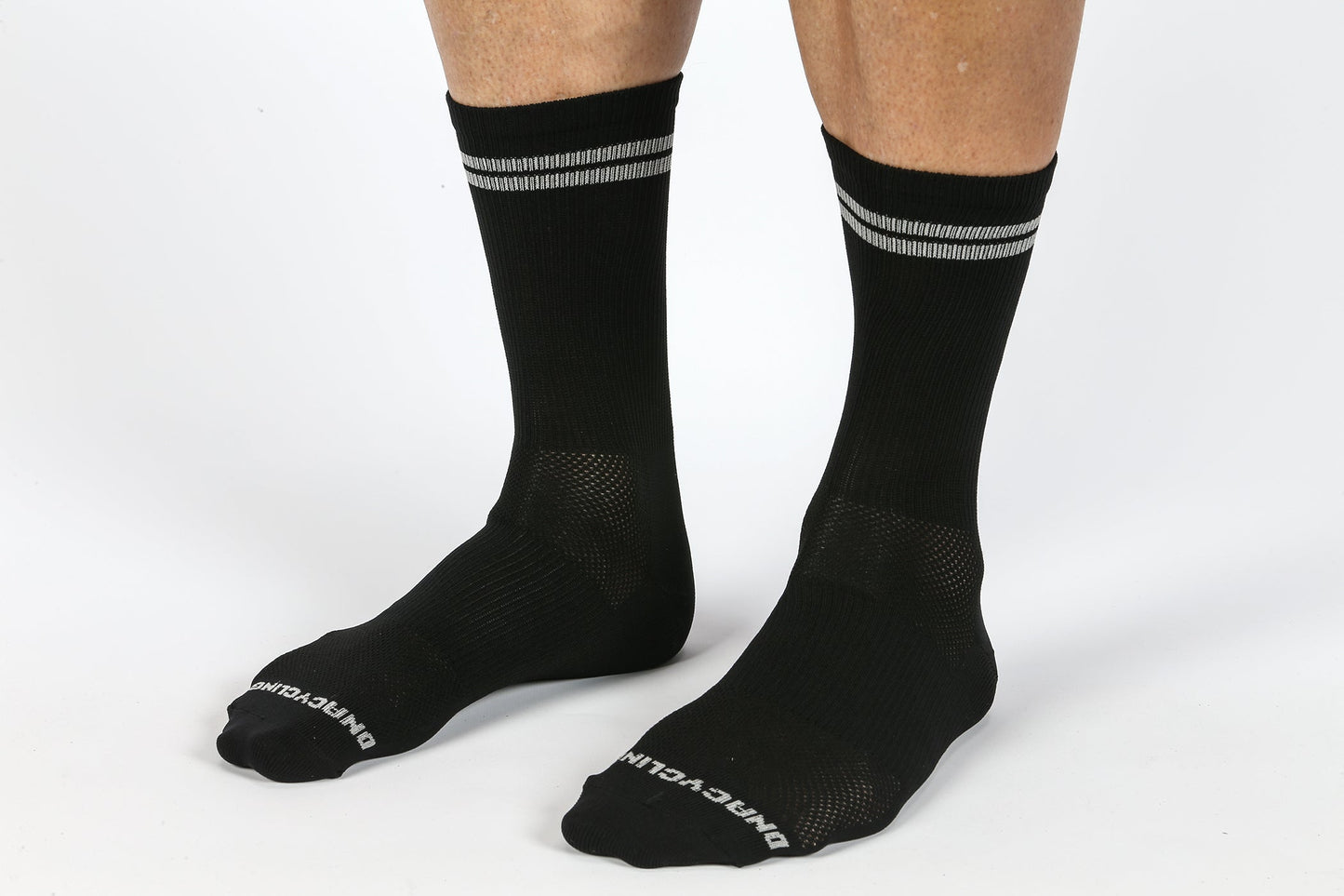 Close-up of a person wearing Masi Bikes MASI DNA CYCLING SOCKS BLACK, with two gray stripes at the top and Dont Walk in white on the toes, set against a white background.