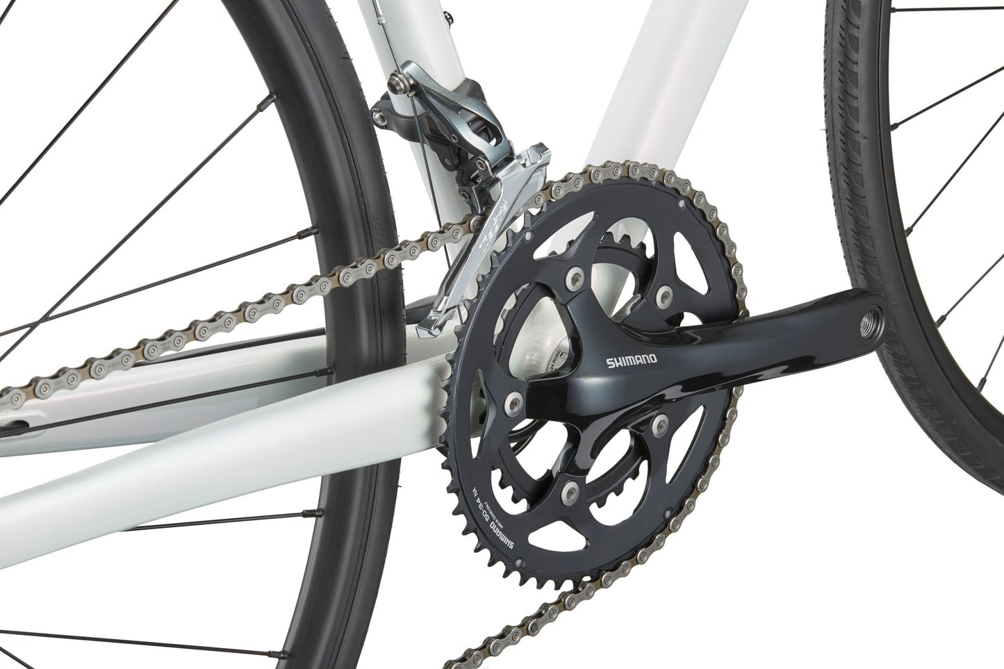 Close-up of a crankset and chain, featuring a black Shimano Tiagra crank arm on a Masi VINCERE 3s white alloy frame and black tires.