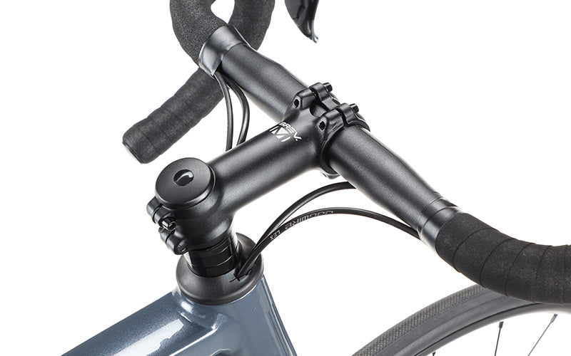 Close-up of a bicycle handlebar with black tape, attached to the sleek metallic blue alloy frame of a Masi Bikes VINCERE 3. The image showcases Shimano Tiagra components, highlighting the mounting bolts and brake cables, focusing on the stem and handlebars.