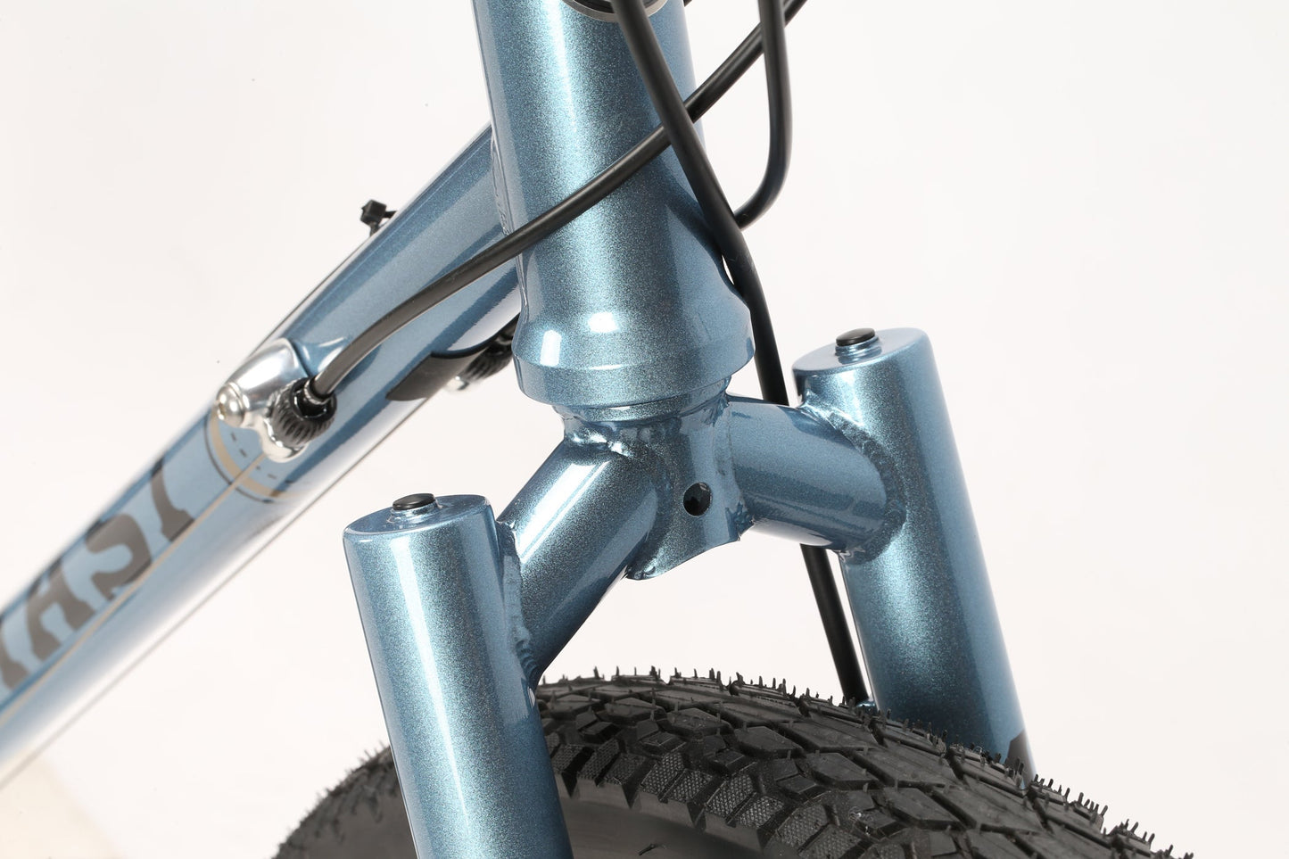 Close-up of the metallic blue GIRAMONDO 700cs head tube, featuring the fork crown, brake cables, and front wheel with a textured tire. The Masi Bikes product is set against a plain white background, ready for adventure.