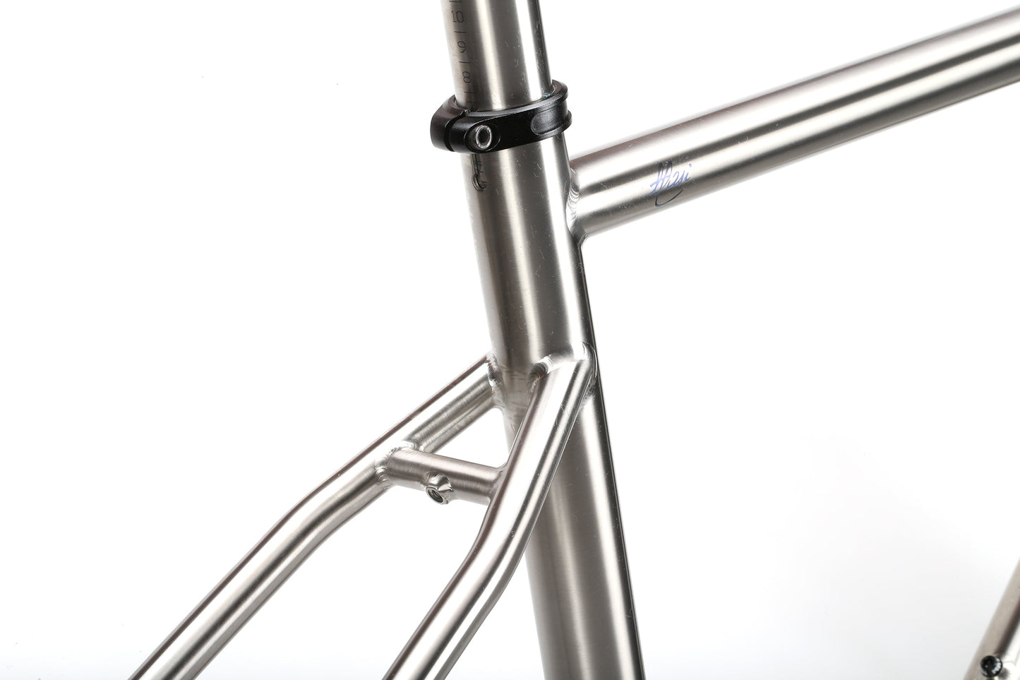 Close-up of the INCANTO Ti FRAMESET by Masi Bikes, featuring the seat tube, top tube, and seat stays. Crafted from 3AL/2.5V titanium tubing with a clamp and smooth welds on a white background, this frame is ideal for gravel biking enthusiasts who value durability and style.