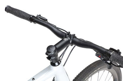 Close-up of BRUNELLO 3s black handlebars and brake levers, with a white frame and textured grips, against a plain white background.