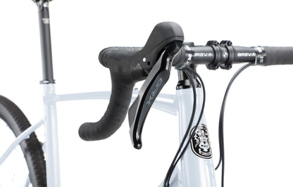 Close-up of a BRUNELLO 1 handlebar and gear shifter with black grips against a white background.