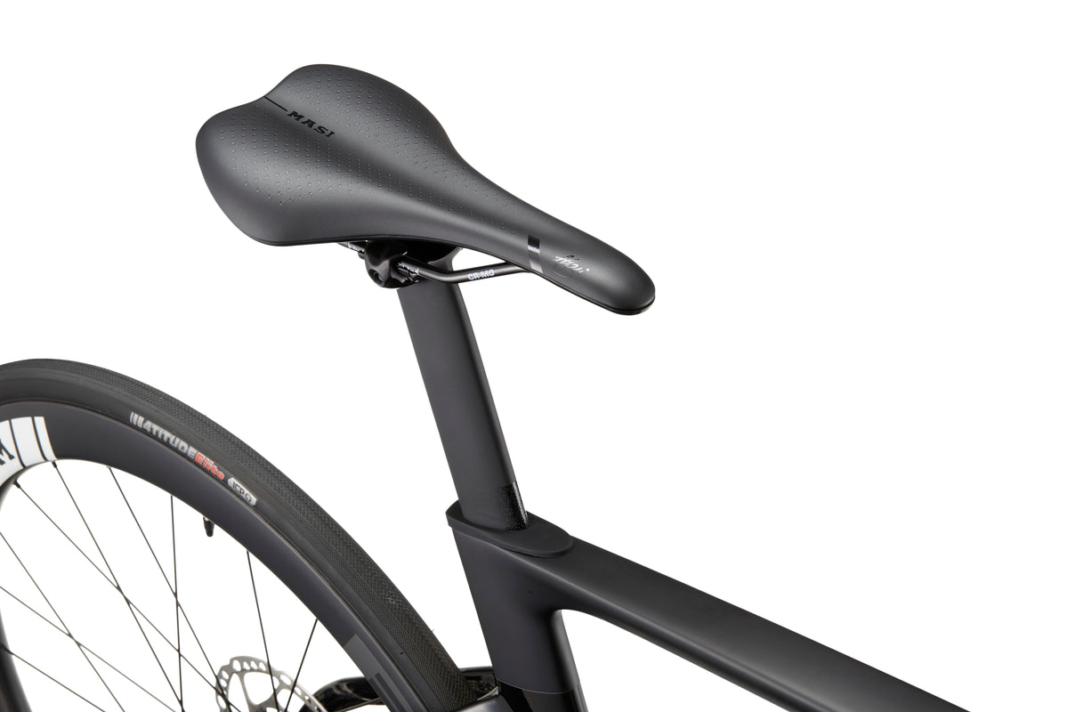 Close-up of a sleek black saddle on an EVOLUZIONE 1, highlighting its rear wheel and part of the aerodynamic carbon frame.