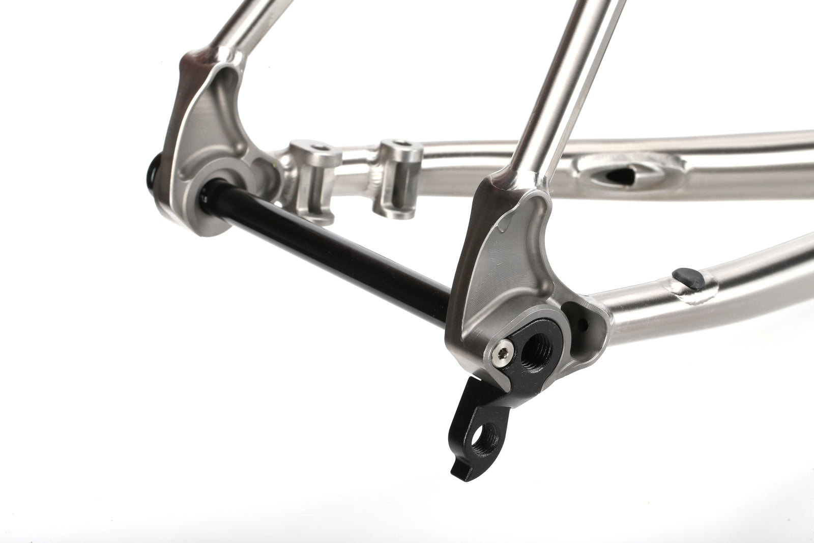 Close-up of a TITANIO FRAME titanium dropout with thru-axle, showing sleek metallic details on a white background.