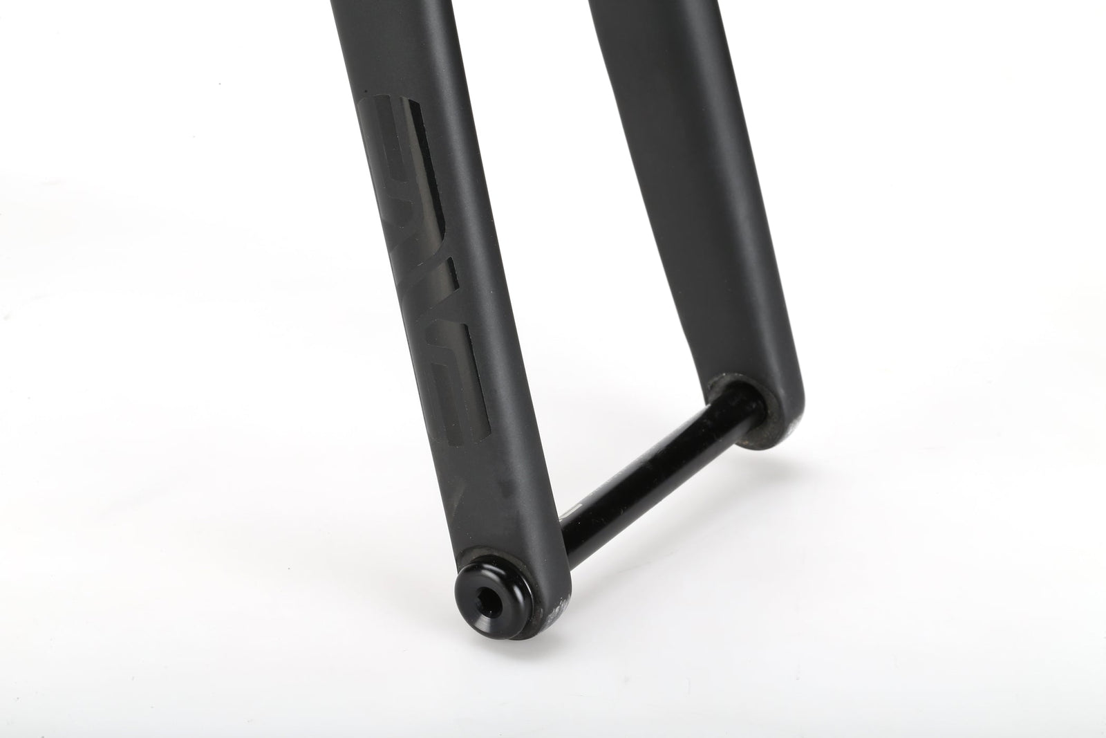 Close-up of the TITANIO FRAME's black fork with axle from a lightweight racing bike, shown on a white background.