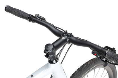 Close-up of the BRUNELLO 3 gravel bike’s black handlebar, stem, and front tire against a white background.